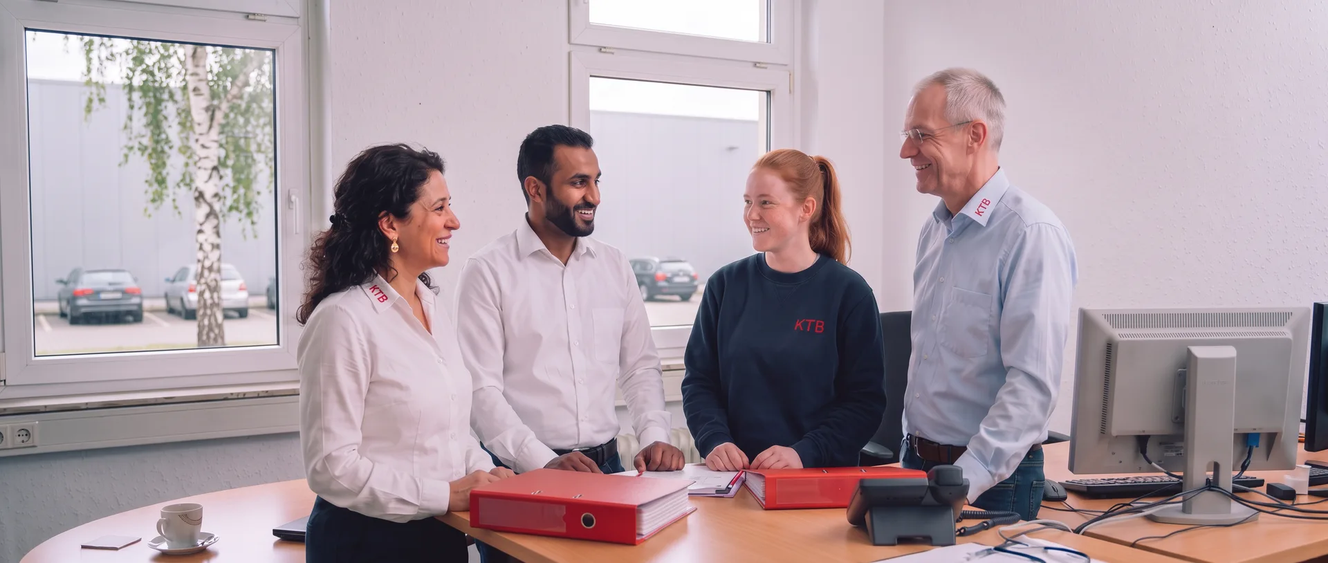 Four KTB employees from office and warehouse talking together